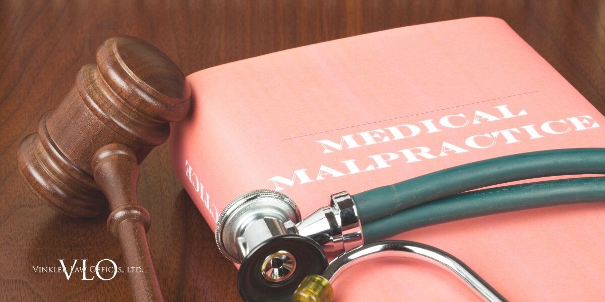 Photo of gavel and book with "medical malpractice" written on it | Medical Malpractice Attorneys in Chicago | Vinkler Law Offices, LTD.