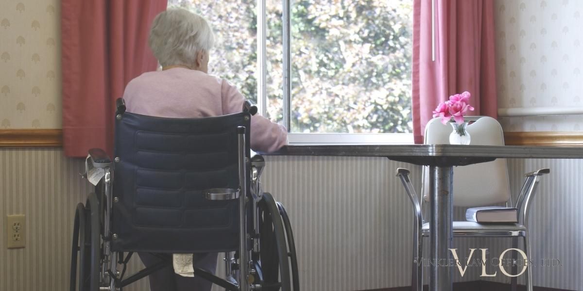 Elderly woman in wheelchair looking out window | Nursing Home Abuse Attorney | Vinkler Law Offices, LTD.