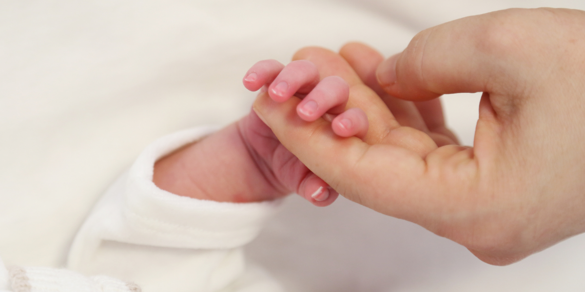 Adult holding hand of newborn baby | Birth injury lawsuits | Vinkler Law Offices, LTD.